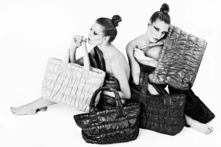 Chic fashion photo of two women with stylish handbags in black and white.